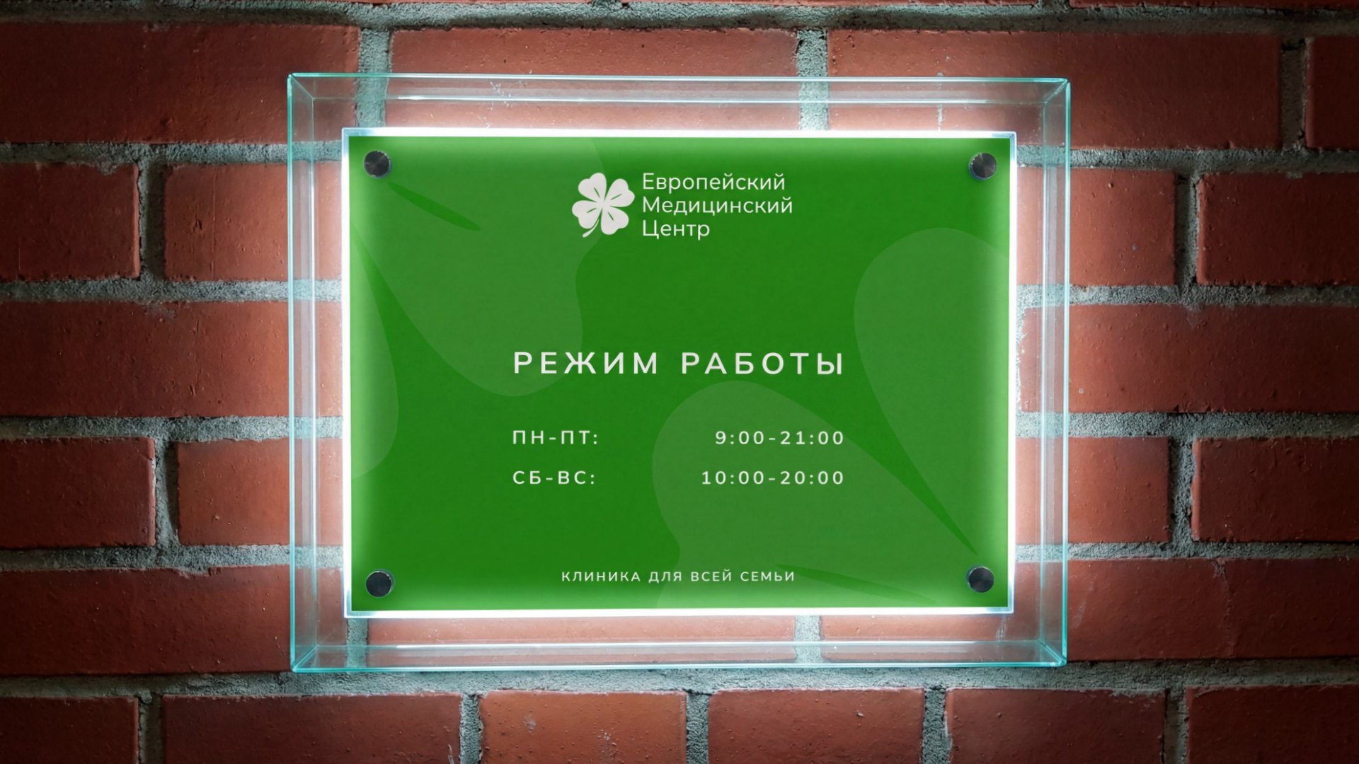 Табличка с режимом работы клиники на зелёном стекле